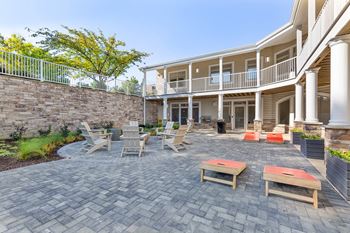 a patio with tables and chairs in front of a house
